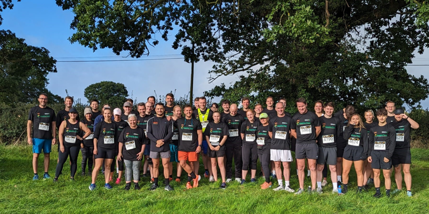 A picture of a group of Oxbury employees ready to run a 10K for charity