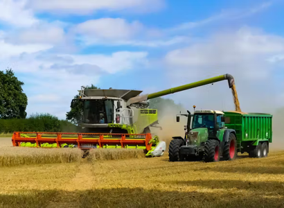 A tractor and a combine harvester working on a field 